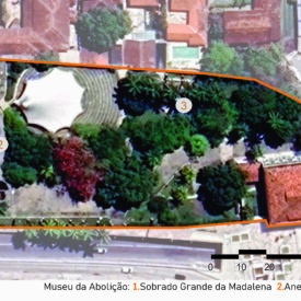 Imagem aérea do terreno do Museu da Abolição, com seus limites destacados em linha laranja. A área é densamente arborizada, com caminhos curvos em meio aos jardins. Três edificações principais estão identificadas por números: 1 — Sobrado Grande da Madalena, localizado no canto inferior direito; 2 — Anexo, à esquerda, próximo à entrada do terreno; 3 — Loja/Café, ao centro, próximo ao teatro de arena. A imagem inclui a legenda com a identificação das edificações, uma escala gráfica no canto inferior direito e, na parte superior esquerda, uma seta indicando o ponto cardeal norte.