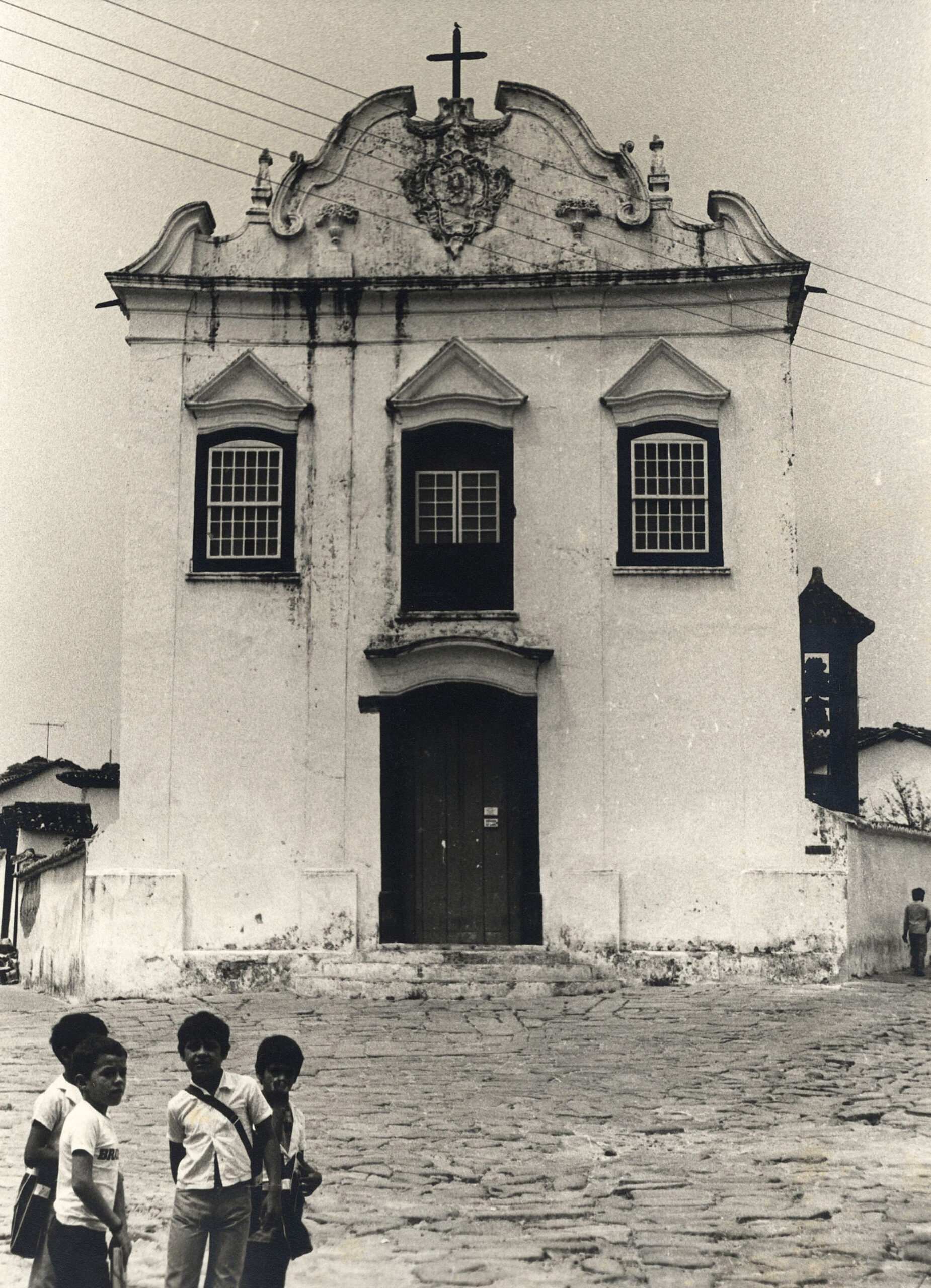 A fachada do Museu está retratada em preto e branco. A porta principal fica ao centro da fachada, encimada por janela central no pavimento superior, com duas janelas ao lado, as três decoradas com cornijas em formato triangular, lembrando pequenos frontões. Completando a composição, no topo da fachada, o frontão ondulado com brasão e cruz.