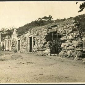 Fotografia histórica do Museu, em tons de sépia. Observam-se os muros da fachada em pedra e as aberturas ao longo de sua estrutura. Nota-se que os muros estão em processo ruim de conservação, com parte deles arruinada, à direita da fotografia.