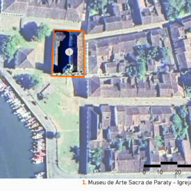 Vista de satélite da área do museu e seu entorno, evidenciando a malha urbana do centro histórico de Paraty. No centro da imagem, um retângulo laranja destaca o conjunto arquitetônico, situado próximo à orla e a uma área verde. A imagem mostra ainda a organização das quadras e o traçado das ruas. A imagem inclui a legenda com a identificação das edificações, no canto inferior direito a escala gráfica e, na parte superior esquerda, uma seta indicando o ponto cardeal norte.
