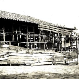 Fotografia histórica, em preto e branco, da fachada do museu com tapumes de proteção. A imagem mostra que o museu estava em avançado processo de deterioração, necessitando de intervenção.