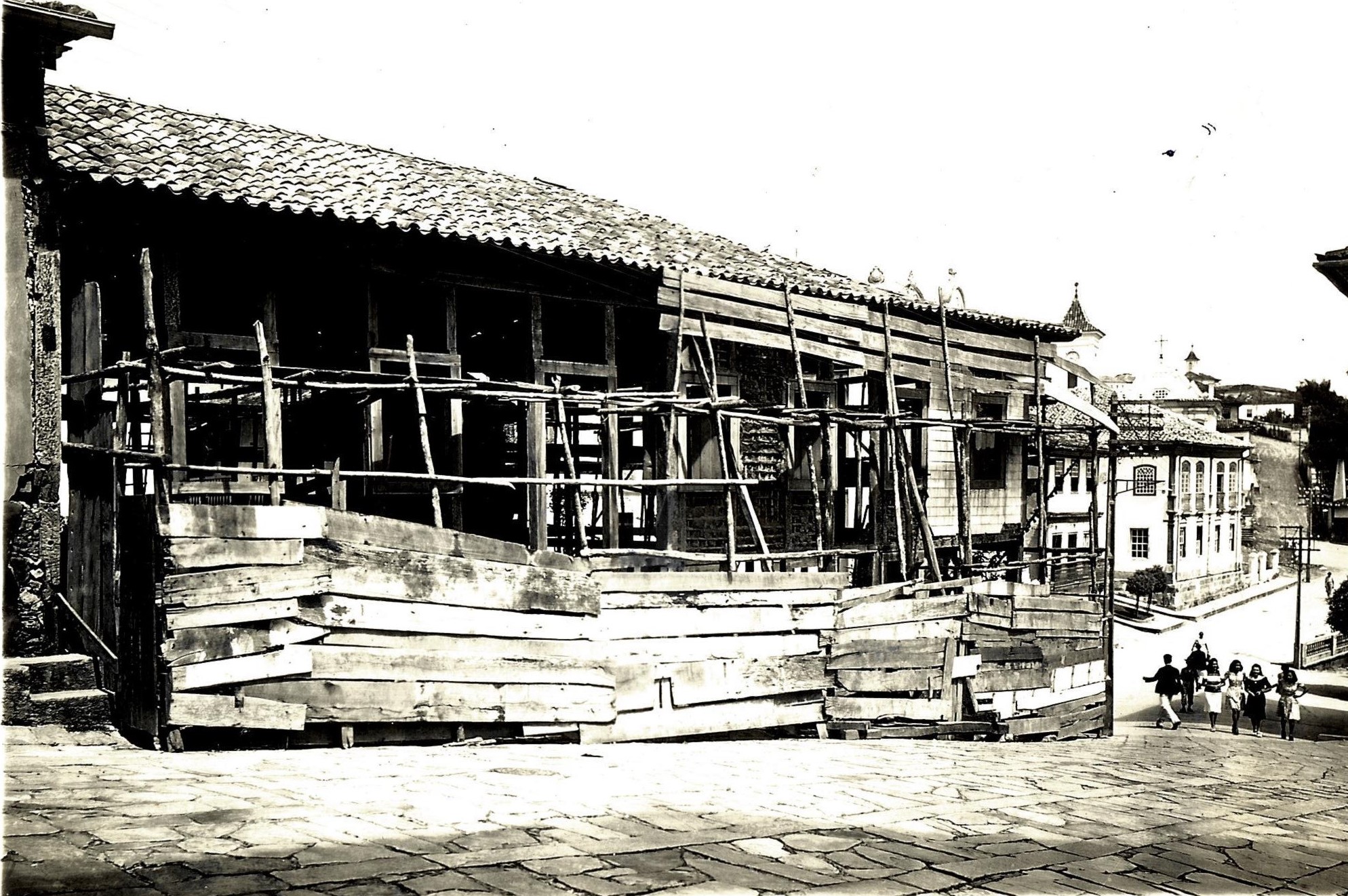 Fotografia histórica, em preto e branco, da fachada do museu com tapumes de proteção. A imagem mostra que o museu estava em avançado processo de deterioração, necessitando de intervenção.
