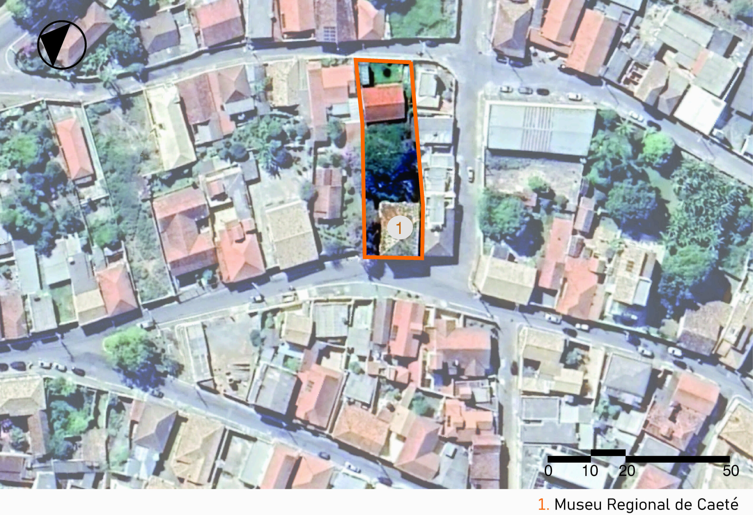 Vista aérea da área urbana com várias construções e poucas áreas verdes. As ruas acompanham o desenho natural do terreno. No centro, há um contorno laranja destacando o terreno do museu. A imagem inclui a legenda com a identificação das edificações, no canto inferior direito, a escala gráfica e, na parte superior esquerda, uma seta indicando o ponto cardeal norte.