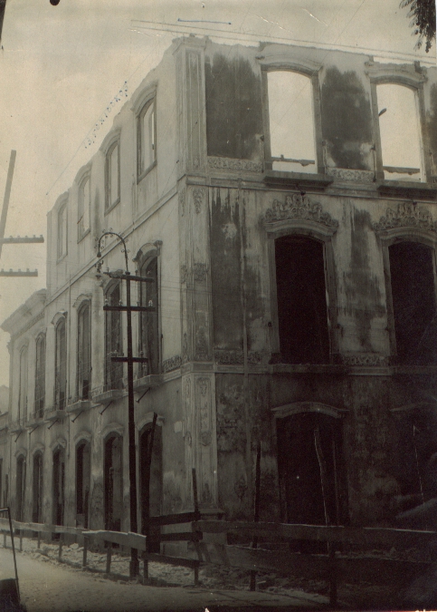 Fotografia histórica do museu, de quando parte do edifício foi demolido. O edifício apresenta andaimes na sua fachada esquerda. Não há janelas, portas e telhados. Os detalhes arquitetônicos, como os frisos e molduras originais, são visíveis.